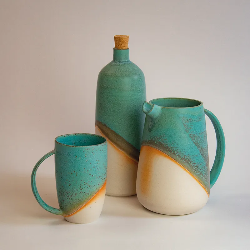 Groupe de céramiques artisanales en grès émaillé, aux teintes turquoise et orange, élégantes et modernes.