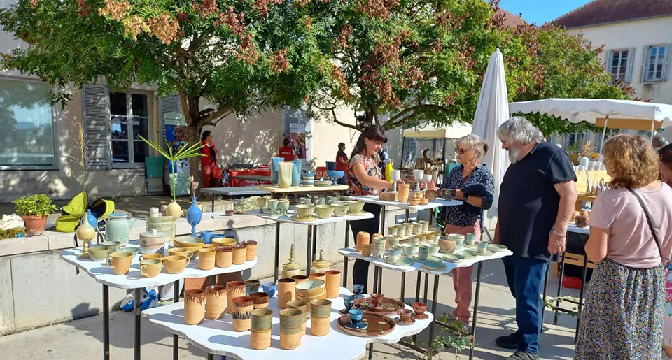 Marché convivial d'artisanat local à Pesmes en Haute-Saône, exposant des créations en céramique colorées.