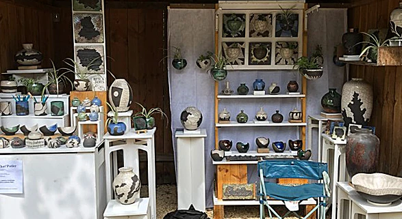 Stand d'artisans au marché, présentant des créations en céramique colorées et modernes, ambiance conviviale et artisanat local.