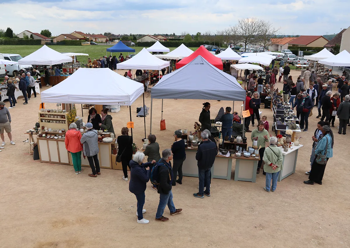 Marché convivial de poterie, ambiance chaleureuse avec de nombreux artisans et visiteurs. Échanges autour de l'artisanat local à Biozat.