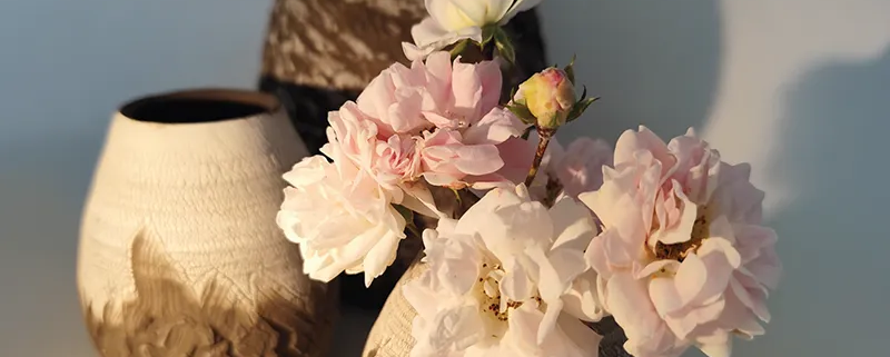 Vase en céramique artisanale, émaillé avec décor floral, accueillant des fleurs délicates dans un style raffiné.