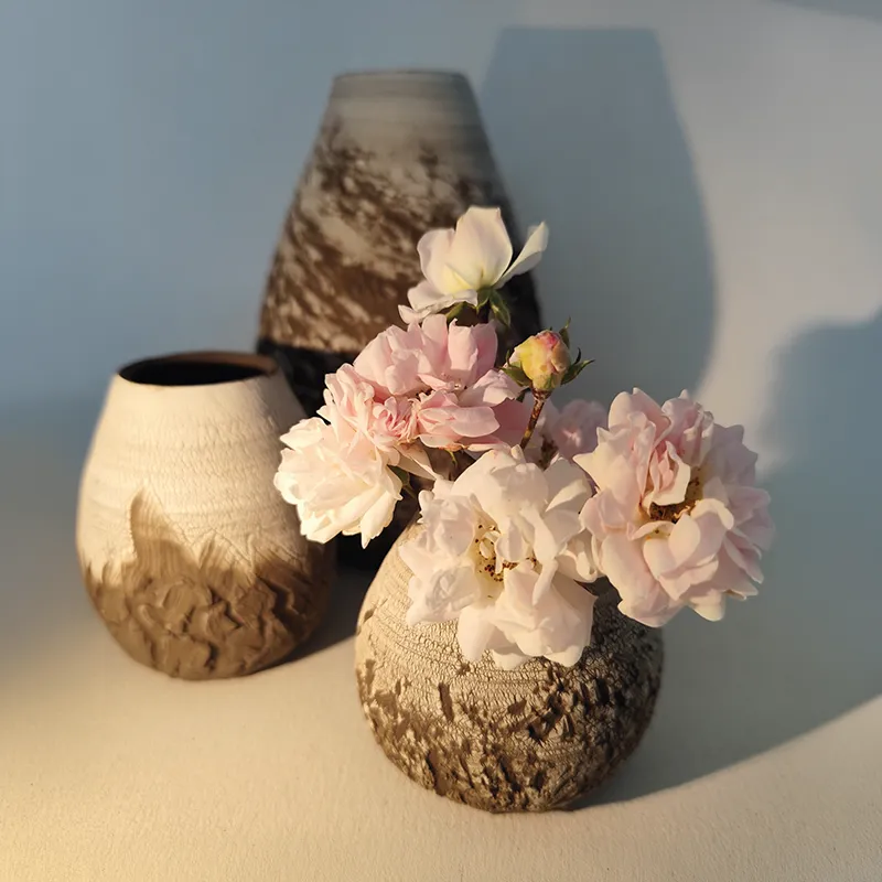 Vase en céramique artisanale, émaillé avec décor floral, accueillant des fleurs délicates dans un style raffiné.