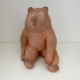 Sculpture en céramique représentant un ours, aux teintes naturelles et aux lignes douces, symbole de l'artisanat local.
