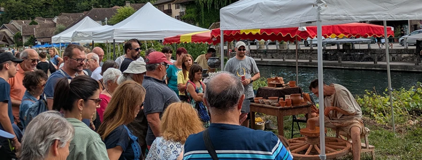 Marché convivial de potiers à Chanaz, artisans en plein travail, ambiance festive au bord de l'eau.