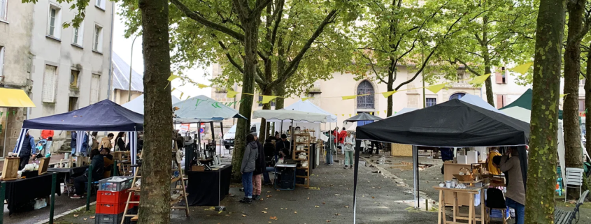 Marché de poterie à Limoges, sous les arbres, ambiance chaleureuse et artisanat local à l'honneur.